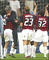 An ecstatic AC Milan coach Carlo Ancelotti jumps on one of his players as he congratulates his team