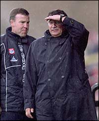 Graham Taylor looks on in the rain as his side lose to Arsenal