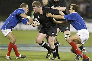 New Zealand's Greg Somerville is held up by the French defence