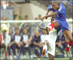 William Gallas volleys the ball ahead of Valery Mezague 