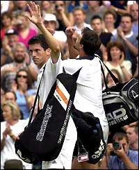 A grim-faced Tim Henman leaves the court after defeat to Goran Invanisevic