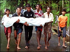 People from Ratnapura carry the body of a flood victim