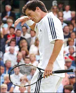 Tim Henman wipes his brow as he loses his serve