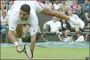 Mark Philippoussis appears to balance on his hands as he returns to Grosjean 