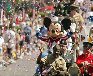 A person dressed as Mickey Mouse rides US soldiers during a parade at Disneyland in Anaheim, California