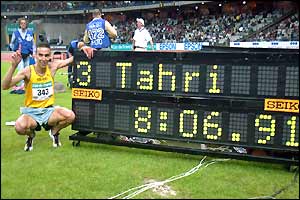 Bob Tahri celebrates next to the scoreboard displaying his European-record time