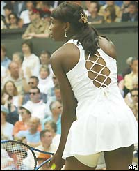 Venus Williams, with her left thigh strapped, serves