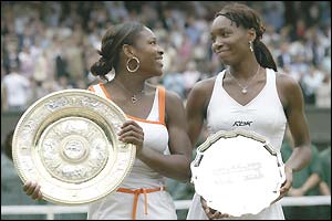 Serena Williams looks at her older sister Venus as the pair pose for the cameras with their trophies