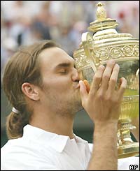 Roger Federer kisses the Wimbledon mens singles winners' trophy