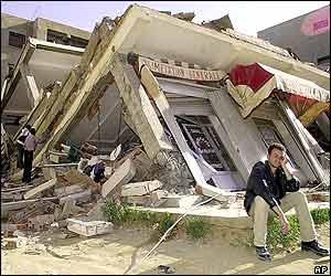 Man sits outside destroyed building in Reghaia