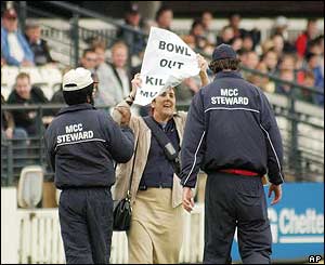 A female protester is lead from the pitch by security guards