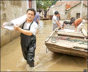 Workers in Anhui try and save paper rolls from a factory