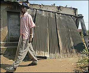 Resident of Bujumbura passes by a destroyed house