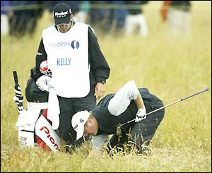 Jerry Kelly and his caddy search for the ball in the rough