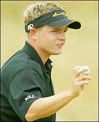 Donald holds up his ball after a birdie on the seventh