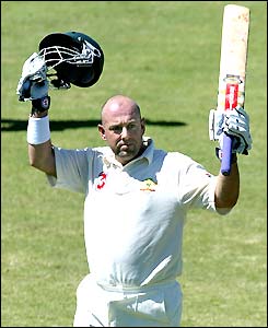 Darren Lehmann raises his bat and helmet after making 100