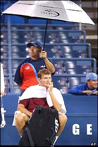 Sjeng Schalken looks glum sitting under an umbrella