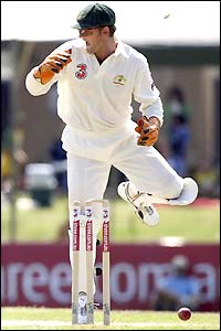 Adam Gilchrist watches as the ball hits the stumps