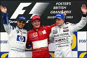 Juan Pablo Montoya, Rubens Barrichello and Kimi Raikkonen celebrate on the podium at Silverstone