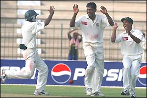 Spinner Mohammad Rafique is mobbed after taking five wickets