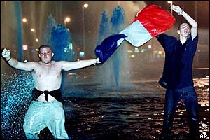 French fans celebrate their victory in a Rotterdam fountain with blue-coloured water in Rotterdam