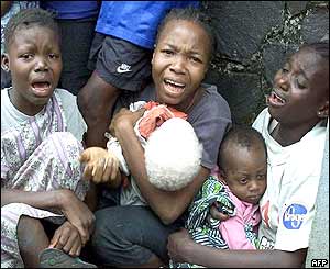 Terrified people try to shelter behind a wall near the US embassy in Monrovia