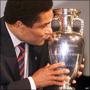 Soccer star Eusebio kisses the Euro trophy after the official announcement that Portugal will host the final round of the Euro 2004 