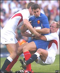 Will Greenwood and Neil Back (right) tackle Yannick Jauzion of France