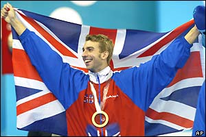 James Gibson holds the Union Jack after his 50m breaststroke win