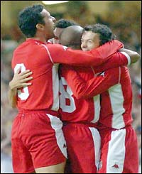A jubilant Wales side embrace scorer Simon Davies