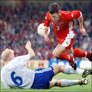 Wales' Jason Koumas hurdles a tackle by Finland's Aki Riihilahti