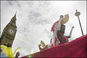 A float complete with exotic dancers passes Big Ben and the Houses of Parliament