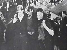 Three miners - one being supported by the other two 