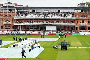 The wicket is covered at Lord's as rain and bad light delays the start of play until 1200 BST