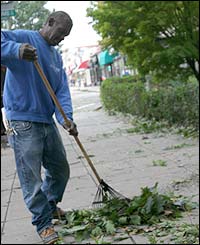 Steve Belzer rakes leaves in front of his apartment