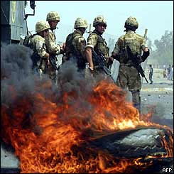 British soldiers stand by burning tires as clashes broke out between Iraqis and British troops 