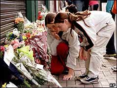 Girls read floral tributes to the victims