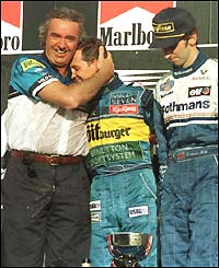 Schumacher is hugged on the podium in 1995