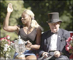 Serena Williams rides with her trophy in a horse-drawn carriage