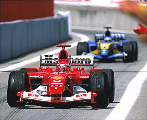 Michael Schumacher pits at Barcelona closely followed by the Renault of Fernando Alonso
