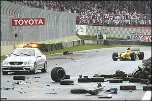 Giancarlo Fisichella's Jordan trails the safety car past the scene of Fernando Alonso's race-stopping shunt at the Brazilian Grand Prix