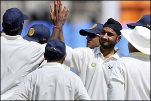 Harbhajan Singh (centre) takes a wicket
