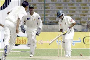 Pakistani spinner Danish Kaneria runs toward wicketkeeper Rashid Latif after clean-bowling Bangladeshi batsman Alok Kapali 