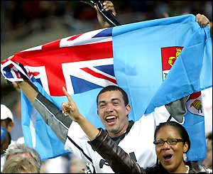 A fan waves the Fijian flag in the crowd