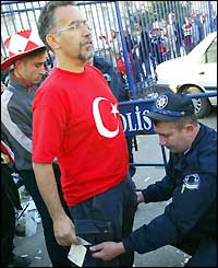 A Turkish fan is searched on his way into the ground