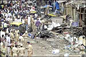 Crowd looks on at the site of a bomb blast at Zaveri Bazar