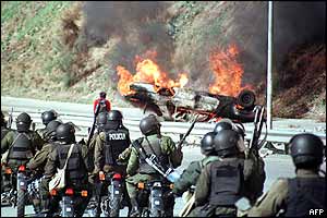 Police at the road that links La Paz to El Alto after protesters set a car alight