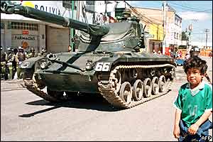 Tanks roll past a boy in El Alto,12 km west of La Paz