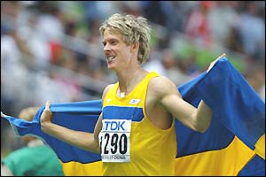 Christian Olsson of Sweden drapes himself in the Swedish flag after winning gold in the triple jump