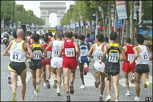 Competitors in the men's marathon run up the Champs-Elysees towards the Arc de Triomphe